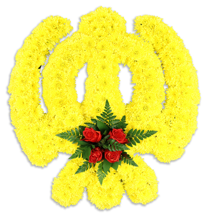 Dominating the frame against a stark white backdrop, this large and meticulously fashioned floral Khanda commands quiet attention. Thousands of tiny, tightly placed yellow chrysanthemum heads build the circular chakkar, the two crossed kirpans, and the central double-edged khanda sword, their compact forms creating a plush, slightly three-dimensional relief that seems to shimmer with a warm, golden intensity. The yellow field is uniformly dense, producing soft shadows across the symbol's curves and imparting a tactile, almost textile-like quality to the composition. At the very centre where the emblem's lines converge, a refined cluster of deep red roses - five or six in number - is nestled within a bed of glossy, dark green fern fronds; the roses' rich, velveteen petals provide a dignified counterpoint and draw the eye inward, while the ferns add an architectural quality that lifts the centre visually. A soft grey shadow beneath the arrangement anchors it as a substantial memorial piece, likely intended for ceremonial use at a service or as a prominent display in a cultural celebration of Sikh heritage in the Epping area. The scent is gentle and comforting: a light chrysanthemum sweetness mingled with the familiar, layered perfume of rose and the cool, green undernotes of fern. This tribute reflects careful craftsmanship familiar to florists who work for local memorials and events around the High Street, the town's community venues, and the quieter lanes bordering Epping Forest, offering both symbolic fidelity and a serene visual presence.