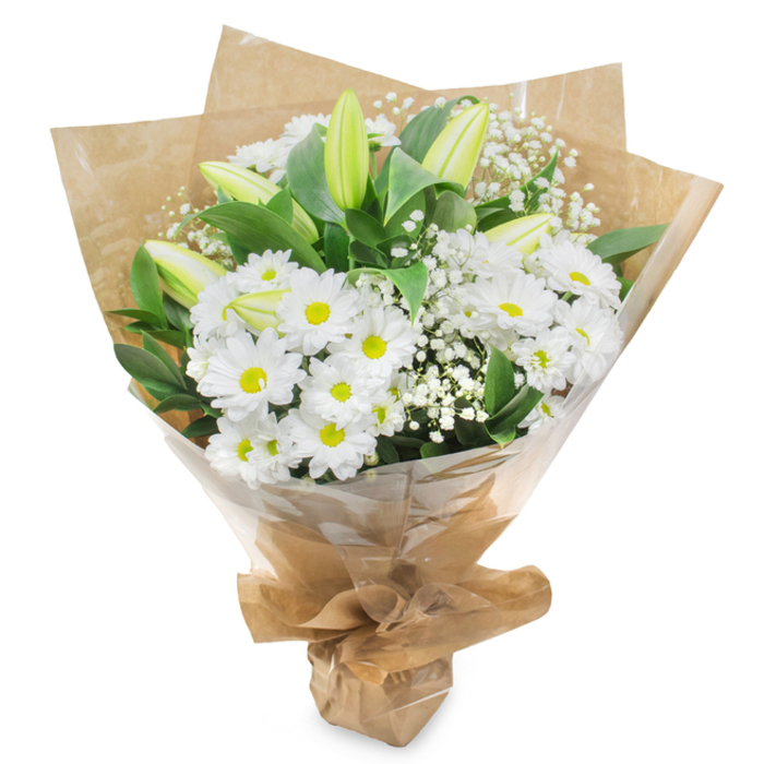 Set against a stark white background, this elegant bouquet of white and green blooms appears almost to float, its details sharpened by the simplicity of the setting. A generous collection of white daisy-like chrysanthemums dominates the centre, their petals cool and pristine, each one fanning out in neat layers from a vivid yellow-green eye. This contrast of bright centres against snowy petals creates a soft, luminous effect, giving the bouquet a welcoming, comforting warmth. Threaded among these daisy heads are several long, closed lily buds, their slender forms washed in pale green that deepens slightly along the edges, with hints of ivory at the tips where the petals will one day unfurl. These buds lean and tilt gently, adding height and structure while suggesting the quiet promise of future blossoms-a message many families in Epping appreciate when choosing flowers for sympathy or remembrance. Around and between the prominent blooms, clusters of delicate white baby's breath drift in and out of view, their tiny star-shaped flowers giving a feathery, cloud-soft texture. Deep, glossy green foliage frames the flowers, the leaves broad and smooth, absorbing and reflecting light in patches that add depth and richness to the composition. The stems are gathered neatly and wrapped first in rustic brown kraft paper, its natural, crinkled surface evoking the earthy calm of Epping's surrounding countryside. Over this sits a layer of clear, slightly crinkled cellophane, providing a subtle sheen and protection without distracting from the flowers. The bundle is drawn together at the base to form a tidy, cone-shaped hand-tied bouquet, the kind of design a local florist in Epping might prepare for a respectful funeral tribute, a hospital visit, or a quiet message of support delivered to a doorstep on a peaceful residential street.