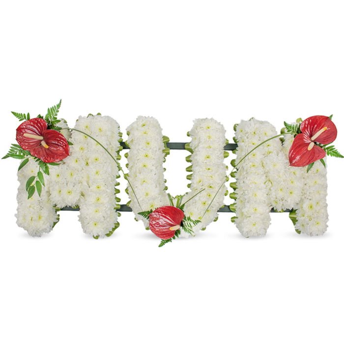 A poignant, hand-crafted memorial piece spells the word MUM in three-dimensional capital letters, each letter built from hundreds of pristine white chrysanthemums packed so closely the surface becomes soft, billowy, and uniform. The compact white blooms create a tranquil, cloudlike texture, their tiny petals suggesting purity and calm. A subtle dark green structural frame peeks out along the sides, defining the silhouette and lending a discreet architectural support that keeps the freestanding letters graceful and precise. The arrangement is animated by three glossy red anthuriums-one placed on the upper left corner of the first 'M', one nested into the lower arc of the 'U', and one adorning the upper right corner of the final 'M'-each with a pale yellow-white spadix that contrasts with the deep red spathe. Around these focal anthuriums sit clusters of rich, dark green foliage and delicate fern sprays whose feathery edges temper the bold geometry and introduce a fresh, woodland note reminiscent of nearby Epping Forest. Thin, arching blades of grass or long green stems link the red accents, flowing across the white letters to visually unite the tribute and guide the eye from left to right. Bathed in gentle daylight, the piece conveys a quiet dignity and warmth-a traditional funeral tribute that reads as loving, respectful, and beautifully restrained. Families choosing this design often mention wanting something that honors memory with simplicity and grace, particularly for services held locally on Epping High Street or at community chapels nearby.