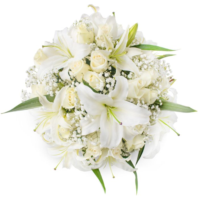 Seen directly from overhead on a pure white surface, this perfectly rounded bouquet presents an elegant study of white and cream textures: large white oriental lilies with open, trumpet-like petals and subtle green stamens sit amid clusters of creamy ivory roses, many held as neat buds or gently opening to reveal their layered centres. Between and around the stronger forms are delicate sprays of Baby's Breath (Gypsophila), their tiny white blossoms forming a soft, frothy cushion that fills negative spaces and lends a cloud-like lightness to the otherwise compact composition. A few fresh green leaves emerge at the perimeter, just enough to define the silhouette and introduce a natural contrast to the monochrome palette. The overhead viewpoint emphasises the bouquet's symmetry and dense assembly, highlighting the careful spacing that keeps the arrangement feeling both abundant and restrained.
Texturally, the lilies' broader, satiny petals contrast with the velvety, tightly furled rosebuds and the fine filamentary structure of the gypsophila, producing a tactile richness you can almost feel by sight. The scent would be quietly sweet and enveloping, a soft mix of lily perfume and rose warmth - appropriate for bridal work or as a dignified centrepiece at a reception in a local village hall near Bell Common or around St John's Road. Designed with a timeless sensibility, the bouquet reads as a celebration of purity and new beginnings while reflecting the steady hand of a florist who understands classical forms and the modest, enduring tastes of the Epping community.