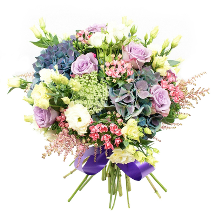 This extraordinary bouquet brings together the vivid botanical character of Epping with the refined skill of a local artisan florist. Framed against a clean, luminous white background, the design is anchored by generous clusters of hydrangeas blooming in luxurious shades of deep indigo, teal-infused purple, and dusky blue-a palette reminiscent of the twilight hours spent near Epping's iconic forest trails. Within the heart of the arrangement, elegant lavender and lilac roses bloom alongside creamy white varieties, their multi-petaled forms opening in layers that convey pure romance and gentle poise. White ranunculus, known for their intricate, ruffled petals, gather in rounded groups for a touchable texture that invites the hand as much as the eye. Rising above and peeking through the core, slender stems of lisianthus buds-soft yellow and green-add graceful height and a refreshing sense of movement. The design is enlivened by sprays of energetic fuchsia-pink filler flowers and the gossamer softness of blush pink astilbe, which flutter around the bouquet's perimeter with airy whimsy. Delicate filigree filler flowers in pale green and white lace thread between the larger blossoms, echoing the wildflower meadows at the edge of Epping's green belt. Robust greenery fills the gaps and provides a vibrant contrast throughout. All stems meet at the base, where they are gathered and finished with a wide, elegantly tied royal purple satin ribbon-a subtle nod to the community's fondness for sophisticated detail. This lavish composition, ideal for birthdays, celebrations, or simply brightening a beloved home near Epping, invites admiration and emotion at every glance, capturing the soul of its surroundings and the hands that arranged it.