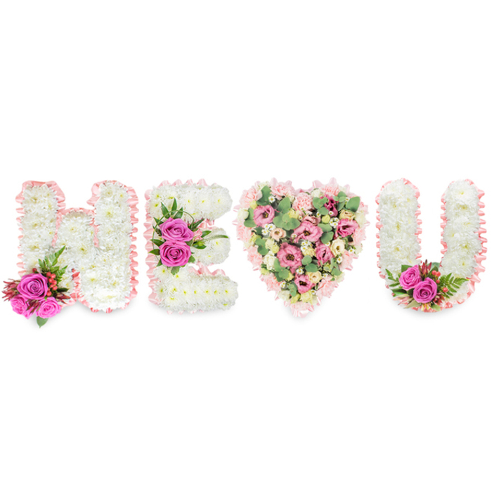 Framed by a pristine white background that lets every petal speak, this floral composition spells out H E (heart) U with meticulous balance and a soft, emotive palette. Each letter - H, E and U - is crafted from a compact bed of pure white chrysanthemums whose repeated tiny blooms form a calm, textured surface reminiscent of fresh linen. A pale blush satin ribbon edges every shape, its whisper of pink providing a gentle finishing touch that unifies the display. Bold fuchsia roses interrupt the white at deliberate points: a bright duo at the lower left of the H, three vivid blooms across the E's centre, and a matching pair nestled within the curve of the U. These roses, set against deep green fern-like leaves and occasional clusters of small red berries, act as visual anchors and bring a warm, fragrant intensity to the overall arrangement. The central heart is softer in mood and hue - a romance of pale pink carnations, delicate lisianthus or small roses, and generous stems of grey-green eucalyptus that add a cool, aromatic presence. Light plays across the satin ribbon edges and the layered petals, revealing subtle shadows that give depth to the letters and roundness to the heart. Crafted with an experienced florist's hand and intended for moments of remembrance or tender celebration, this piece would sit respectfully by a service in Epping or at a private family gathering, offering a clear, personal message of love and memory.