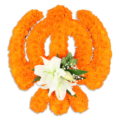 This composition, prepared by Flowers Epping with the eye of a local artisan, transforms thousands of small, sunlit orange marigold florets into the sacred Khanda emblem, set crisply against a white field. The marigolds are pressed close together to build up the curved chakkar, the parallel sweep of the crossed kirpans, and the suggestion of a central double-edged blade, producing a lush, tactile surface that lifts light and shows subtle shadowing around the edges. Directly at the symbol's heart, where strength and spirit converge, a cluster of immaculate white lilies anchors the design: two or more fully open blooms with gently unfurling petals, pale green and yellow stamens visible, accompanied by tight buds that promise more blossom. Surrounding foliage-deep green, glossy leaves-and feathers of tiny white gypsophila soften the transition from vivid orange to pure white and add a faint, cooling fragrance beneath the marigolds' richer scent. The composition reads as both a ceremonial offering and a crafted display, the kind of tribute we might deliver for a community observance near Epping Market or for a quiet memorial on Station Road. The piece's clean silhouette and delicate drop shadow suggest a removable centrepiece, assembled with attentive technique and an understanding of colour, texture and spiritual symbolism appropriate for festivals like Vaisakhi or a respectful temple decoration in the local neighbourhood.