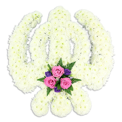 A large, custom Sikh Khanda tribute fills the frame, its iconic silhouette carefully shaped from a carpet of white chrysanthemums that appear freshly cut and expertly conditioned. The central Khanda blade rises straight and true, embraced by the circular chakra and the outward-sweeping kirpans, each edge crisply defined despite the softness of the petals. Every flower head is tightly clustered, creating a padded, cloud-like surface that looks cool and velvety to the touch, as if it would release a gentle green, garden scent familiar to anyone who walks the lanes around Epping High Street. Set at the lower centre of the piece, where the two curved kirpans meet, a small cluster of accent blooms forms a gentle heart to the design. Three pink roses, their spiralled petals unfurling in delicate layers, are framed by smaller, rich purple flowers-perhaps lisianthus or freesias-and feathery green fern. These colours stand out vividly against the white, offering a sense of warmth and personal love within a predominantly serene, ivory palette. The tribute rests against a spotless white background, free from distraction, so that the sacred Sikh emblem and its floral craftsmanship stand in quiet focus, much like a contemplative moment in one of Epping's peaceful places of worship. This arrangement would be chosen for Sikh funerals, cremation services, or memorial gatherings, expressing reverence, spiritual strength, and the enduring bond of family. It shows the steady hand of an experienced florist, carefully balancing tradition with the comforting beauty of fresh, seasonal flowers.
