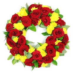 A large, circular floral wreath is carefully presented on a pure white background, its rich colours and textures drawing the eye into a calm, contemplative space. The form is a perfect ring with an open centre, symbolising continuity and unending remembrance, created from a dense tapestry of deep red roses and luminous yellow chrysanthemums. Each red rose is fully open yet still structured, with velvety petals curling outwards from a tightly cupped core to looser, softer edges that shift subtly from clear crimson to a darker wine-red, adding quiet drama. Nestled around and between these roses are clusters of small yellow chrysanthemums, their many fine, thread-like petals forming cheerful, rounded blooms that lighten the whole design. The yellow flowers offer a sense of hope and gentle brightness, reminiscent of sunlight breaking through clouds over the fields near Epping. Enveloping the blooms is a generous layer of foliage, likely including salal and eucalyptus, with leaves in varied shapes and greens-some smooth and glossy, others with a delicate blue-grey cast-creating a textured cushion that feels both natural and composed. The flowers are placed close together so that the wreath looks lush and substantial from every angle, reflecting the steady, attentive work of an experienced florist preparing a funeral tribute for a local church or crematorium around Epping. The neutral white background and soft, even lighting intensify the reds, yellows, and greens, allowing every detail to stand out clearly. Overall, the design conveys affection, respect, and a warm, dignified farewell, ideal for memorial services or graveside tributes in the surrounding community.