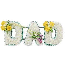 A lovingly composed sympathy tribute that spells DAD in three large, freestanding letters, each letter densely covered in immaculate white chrysanthemums to create a smooth, velvet-like surface. The letters are edged with a ruffled, rich dark green satin ribbon which provides a crisp outline and a refined contrast to the white clusters, while discreet dark green metal bars connect the trio into a single, stable display. The left-hand D is brightened on its upper left curve with a sun-warmed cluster of yellow roses - three to four full blooms - combined with small white filler blooms and fresh green foliage; a pair of long, leafless green stems sweep diagonally toward the centre, lending a subtle, upward motion. The A in the middle bears a sophisticated group of two deep purple or burgundy calla lilies nestled low on its left diagonal, their smooth, sculpted forms offering a quiet focal point amid gentle white sprays. The right-hand D mirrors the left with an identical arrangement of sunny yellow roses and delicate white accents. The overall scent is soft and clean, rose-forward with a hint of green, and the textures move from the plush chrysanthemums to the satiny ribbon and crisp calla petals. As an experienced local florist serving Epping High Street and nearby communities, Flowers Epping composes this piece for funerals and memorials, mindful of local customs and delivered with careful handling; it reads as both a formal tribute and a personal farewell, resonant with warmth, respect, and a steady, comforting presence.