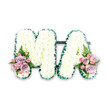 A dignified funeral flower tribute spelling out MA in large, block letters is presented against a stark white background, allowing every petal and detail to stand out clearly, much as it would when prepared for a solemn service in Epping. The letters are crafted on a shared base so they sit neatly in a straight line, each form fully covered in crisp white chrysanthemums. These blooms are tightly packed together, creating a plush, cloud-like surface that appears both soft and substantial. No stems or gaps are visible, only the textured sea of white petals. Around the perimeter of both letters runs a striking dark green ribbon, folded into tiny ruffles that catch the light. This trim delineates the shapes of the M and the A, sharpening the outline and adding a sense of polish and care. At the lower left of the M and the lower right of the A, complementary sprays of accent flowers bring warmth and gentle colour. The clusters feature blush-pink roses and lilac or lavender-toned roses, interwoven with smaller pink spray roses that provide layers of interest. Soft green ferns and foliage tuck around the roses, introducing a fresh, garden-like feel that would not be out of place near the leafy lanes leading towards Epping Forest. The design feels deeply personal, suggesting a tribute for a mother, Mama, or someone remembered by the initials M.A. While the image is straightforward and uncluttered, the meticulous arrangement of each chrysanthemum and the thoughtful placement of the side sprays reflect the quiet skill of a professional florist, capturing love, memory, and respect in floral form.