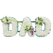 This photograph presents a carefully crafted funeral tribute spelling out the word DAD in bold, three-dimensional letters, designed in a classic style that many families around Epping choose for a father's farewell. Each letter is fully covered with pristine white chrysanthemums, arranged so tightly that the blooms form a continuous, padded surface with a gentle, cloud-like appearance. Their petals are short and neat, creating a uniform texture that speaks of order, care, and respect. Framing the outside of every letter is a pleated band of emerald green ribbon, its ruffled edges lifting slightly to give definition and echoing the lush greenery found around Epping Forest and the local parks. Behind the flowers, you can just make out the dark horizontal bars of the supporting frame, indicating that the piece is meant to stand upright beside a coffin, at the front of a church, or in a crematorium chapel. The upper left curve of the first D features a delicate spray of white freesia and vibrant foliage, adding a slightly raised point of interest. From here, two long, elegant green stems sweep diagonally towards the central A, guiding the eye across the word. At the base of these stems sits a striking accent: two deep purple calla lilies, their smooth, sculpted trumpets emerging from a nest of white freesia blooms and fresh green leaves. This subtle yet rich burst of colour offers contrast without overwhelming the gentle palette. The final D carries a complementary, smaller arrangement of white freesia and greenery on its upper right side, keeping the tribute visually balanced. The whole design exudes tenderness and quiet reverence, a floral expression of love, grief, and lasting gratitude for a much-missed dad.